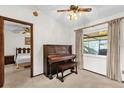 Bedroom featuring carpeted floors, natural light, and vintage-style piano at 3218 Cimarron Dr, Orlando, FL 32829
