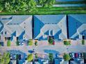 Overhead view of townhomes with orderly roofs, manicured landscaping, paved driveways, and organized parking spots at 3461 Home Town Ln, St Cloud, FL 34769