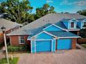Bright brick townhome with a two-car garage, complemented by lush greenery and a well-maintained roof at 3461 Home Town Ln, St Cloud, FL 34769