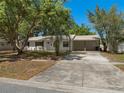 Charming single-story home featuring lush mature trees and a convenient carport at 5326 Weirwood Ave, Orlando, FL 32810