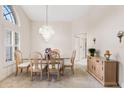 Dining room with a glass table, wooden chairs, a chandelier, and a large window at 58 Golf View Dr, Ocala, FL 34472