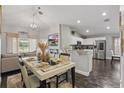 Open-concept dining area adjacent to kitchen and living room, featuring modern decor and ample natural light at 634 Chadbury Way, Kissimmee, FL 34744