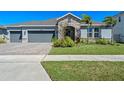 Inviting single-story home with manicured lawn and stone detailing, presenting a well-maintained and attractive exterior at 690 Blue Citrus Ln, Minneola, FL 34715