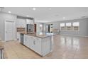 Open-concept kitchen with granite counters, a center island, stainless steel appliances, and seamless flow into the living space at 690 Blue Citrus Ln, Minneola, FL 34715