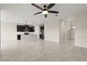 Open-concept kitchen and living area with stainless steel appliances and modern dark cabinets at 8991 Fluffy Lie Ct, Davenport, FL 33896