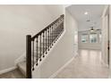 View of the staircase with carpet steps and rod iron spindles leading to the upper level at 8991 Fluffy Lie Ct, Davenport, FL 33896