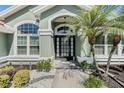 Inviting front entrance with a modern door, decorative landscaping, and a stone walkway at 907 Ridge Spring Ct, Apopka, FL 32712