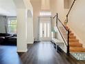 Inviting foyer with hardwood floors, a staircase with a black railing, and ample natural light at 9076 Lake Avon Dr, Orlando, FL 32829
