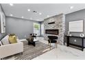 Modern living room with a stone accent wall, electric fireplace, recessed lighting, and stylish decor at 116 Alcala Dr, Kissimmee, FL 34758