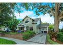 Daytime view of a two-story home featuring a brick paved driveway and mature trees at 13 Hill Ave, Orlando, FL 32801