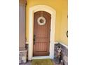 Close-up of a stylish front door with decorative wreath and brick accents at 15707 Cutter Sail Pl, Winter Garden, FL 34787