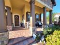 Inviting front porch with brick flooring, decorative columns, and comfortable seating at 15707 Cutter Sail Pl, Winter Garden, FL 34787