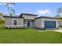 Single story home with a two-car garage, manicured lawn, and paver driveway at 15823 Sw 27Th Avenue Rd, Ocala, FL 34473