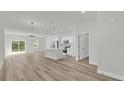 Bright, open-concept living space with modern wood-look floors, white kitchen, and abundant natural light at 15823 Sw 27Th Avenue Rd, Ocala, FL 34473