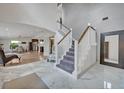 Elegant foyer with marble floors, staircase with white railings, and a view of the living and dining areas at 1661 Woodland Ave, Winter Park, FL 32789