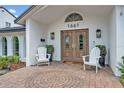Inviting home entrance with double doors, white chairs, and decorative brickwork at 1661 Woodland Ave, Winter Park, FL 32789