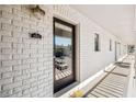 Condo entrance with a glass paneled door, white brick, and hallway view at 2912 Plaza Terrace Dr # 2912, Orlando, FL 32803