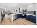Modern kitchen featuring two-tone cabinets, stainless steel appliances, and open concept to living room at 2912 Plaza Terrace Dr # 2912, Orlando, FL 32803