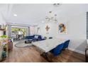 Bright living room with a modern chandelier and a dining area with table and blue chairs at 2912 Plaza Terrace Dr # 2912, Orlando, FL 32803