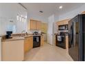 Well-lit kitchen with sleek black appliances and modern cabinetry at 305 Terrace Ridge Cir # 305, Davenport, FL 33896