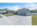 Beautiful single-story residence featuring a lush lawn, elegant gray paint, and a convenient two-car garage at 344 Highland Meadows St, Davenport, FL 33837