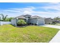 Attractive single-story house showcasing a vibrant lawn, stylish gray exterior, and a two-car garage at 344 Highland Meadows St, Davenport, FL 33837