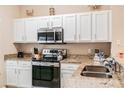 Modern kitchen with white cabinets, granite countertops, and stainless steel appliances at 4504 Alberto Cir, Kissimmee, FL 34746
