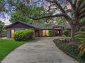 Charming home with mature trees, beautiful landscaping and a long driveway leading up to the front entrance at 6084 Masters Blvd, Orlando, FL 32819