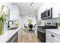 Modern kitchen featuring white cabinetry, stainless steel appliances, and an adjacent dining area at 730 Georgia Ave, Longwood, FL 32750