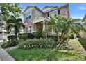 Attractive two-story home showcasing tropical landscaping, a covered front porch, and a neatly maintained lawn at 8111 Pacific Loon St, Winter Garden, FL 34787