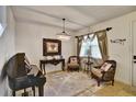 Elegant living room featuring a piano, chandelier, classic furnishings, and neutral tones at 8111 Pacific Loon St, Winter Garden, FL 34787
