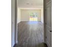 Spacious living room with luxury vinyl flooring and sliding glass doors to the backyard at 978 Commons Way, Port Orange, FL 32129