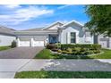 Attractive home with a two-car garage, brick driveway, beautiful landscaping, and a covered entryway at 16238 Misty Hills Ave, Winter Garden, FL 34787