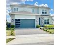 Two-story home with a modern garage door, stone accents, manicured landscaping, and a paver driveway at 10275 Park Estates Ave, Orlando, FL 32836
