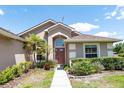 Inviting front entry with manicured landscaping, arched window and a stylish front door at 1054 Windswept Ct, Ocoee, FL 34761