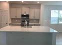 Open kitchen with stainless steel appliances, island and white cabinets at 1169 Happy Forest Loop, Deland, FL 32720