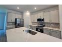Modern kitchen boasts stainless steel appliances, a center island, and sleek countertops at 1169 Happy Forest Loop, Deland, FL 32720