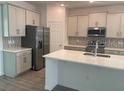 Open kitchen with stainless steel appliances, island and white cabinets at 1169 Happy Forest Loop, Deland, FL 32720