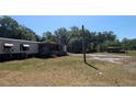 View of home with a covered porch, surrounded by trees and a large grassy yard at 1275 Arapaho Trl, Geneva, FL 32732