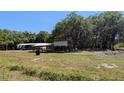 Spacious yard featuring a home and a covered work or storage area at 1275 Arapaho Trl, Geneva, FL 32732