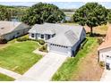 Charming single-story home with a well-maintained lawn and an attached two-car garage near a lake at 14723 Peppermill Trl, Clermont, FL 34711