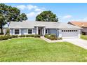 Charming single-story home with a well-maintained lawn and an attached two-car garage at 14723 Peppermill Trl, Clermont, FL 34711