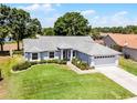 Charming single-story home with a well-maintained lawn and an attached two-car garage at 14723 Peppermill Trl, Clermont, FL 34711