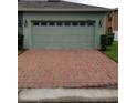 A large two car garage with a brick driveway offers ample parking and curb appeal at 14867 Driftwater Dr, Winter Garden, FL 34787
