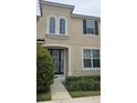 Charming two-story home with a black-framed front door, arched window and well-maintained landscaping at 1569 Carey Palm Cir, Kissimmee, FL 34747