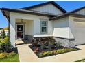 Inviting front entrance with colorful landscaping and a cozy, covered porch at 2075 Huntsman Ridge Rd, Clermont, FL 34715