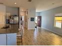 Open-concept living area with wood-look flooring that connects a stylish kitchen with stainless appliances at 2075 Huntsman Ridge Rd, Clermont, FL 34715