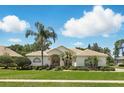 Charming single-story home with lush landscaping, palm trees, and a tile roof at 216 Hammock Oak Cir, Debary, FL 32713