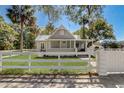 Attractive exterior of a home with a classic white fence, lush lawn, and well-maintained landscaping at 246 N Oak Ave, Orange City, FL 32763
