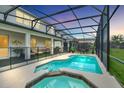Backyard features a private screened-in pool with an attached jacuzzi and outdoor seating at 2616 Calistoga Ave, Kissimmee, FL 34741
